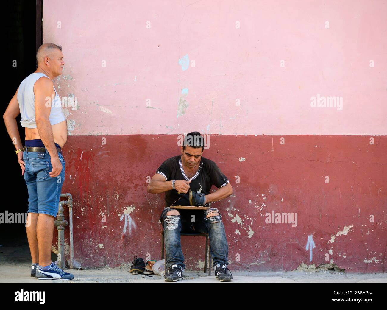 Calzolaio ripara le scarpe sulla strada, Havana Vieja, Cuba Foto Stock