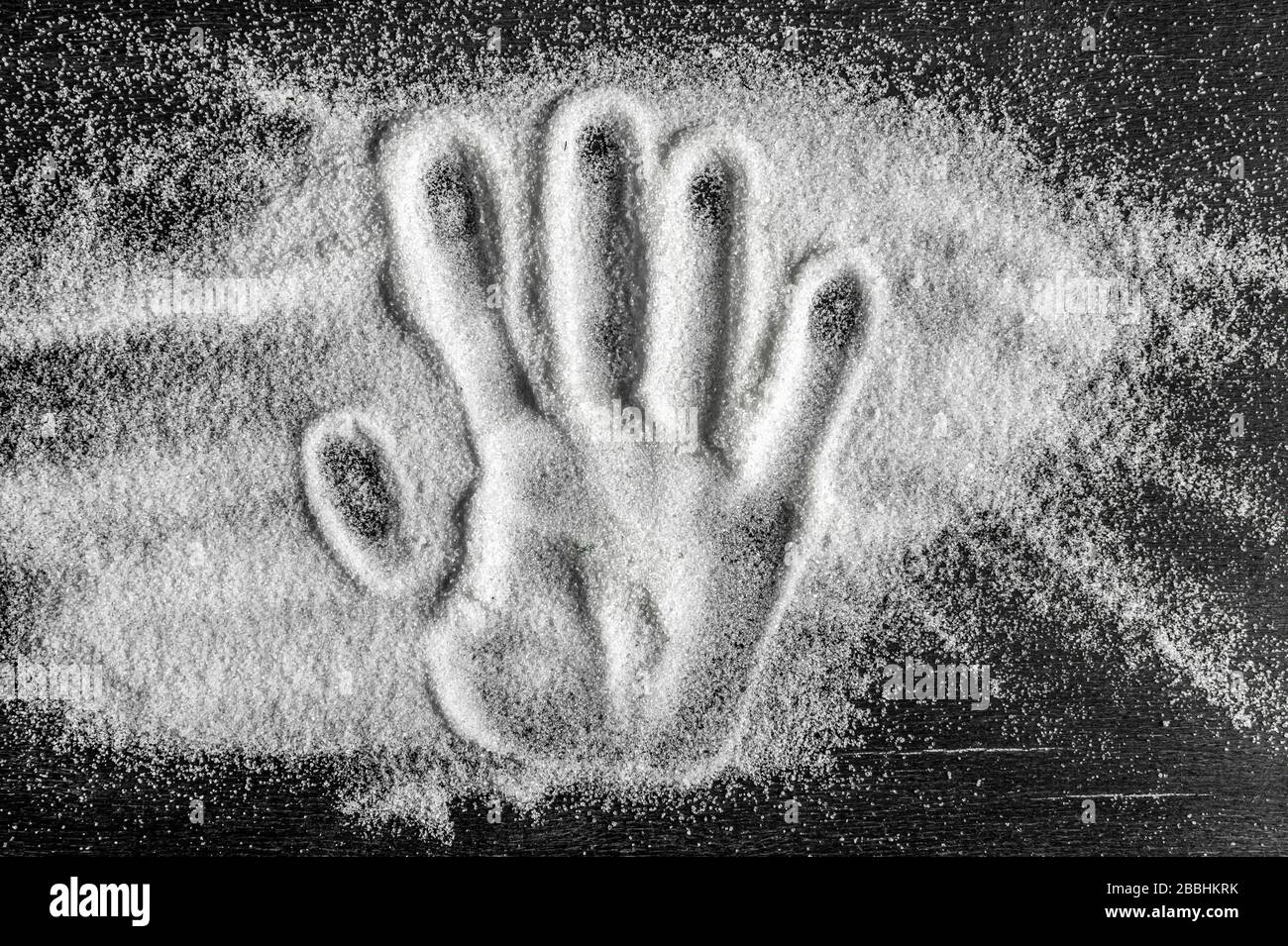 vista dall'alto della stampa manuale sulla sabbia di zucchero sparsa. concetto di dieta, controllo del diabete Foto Stock