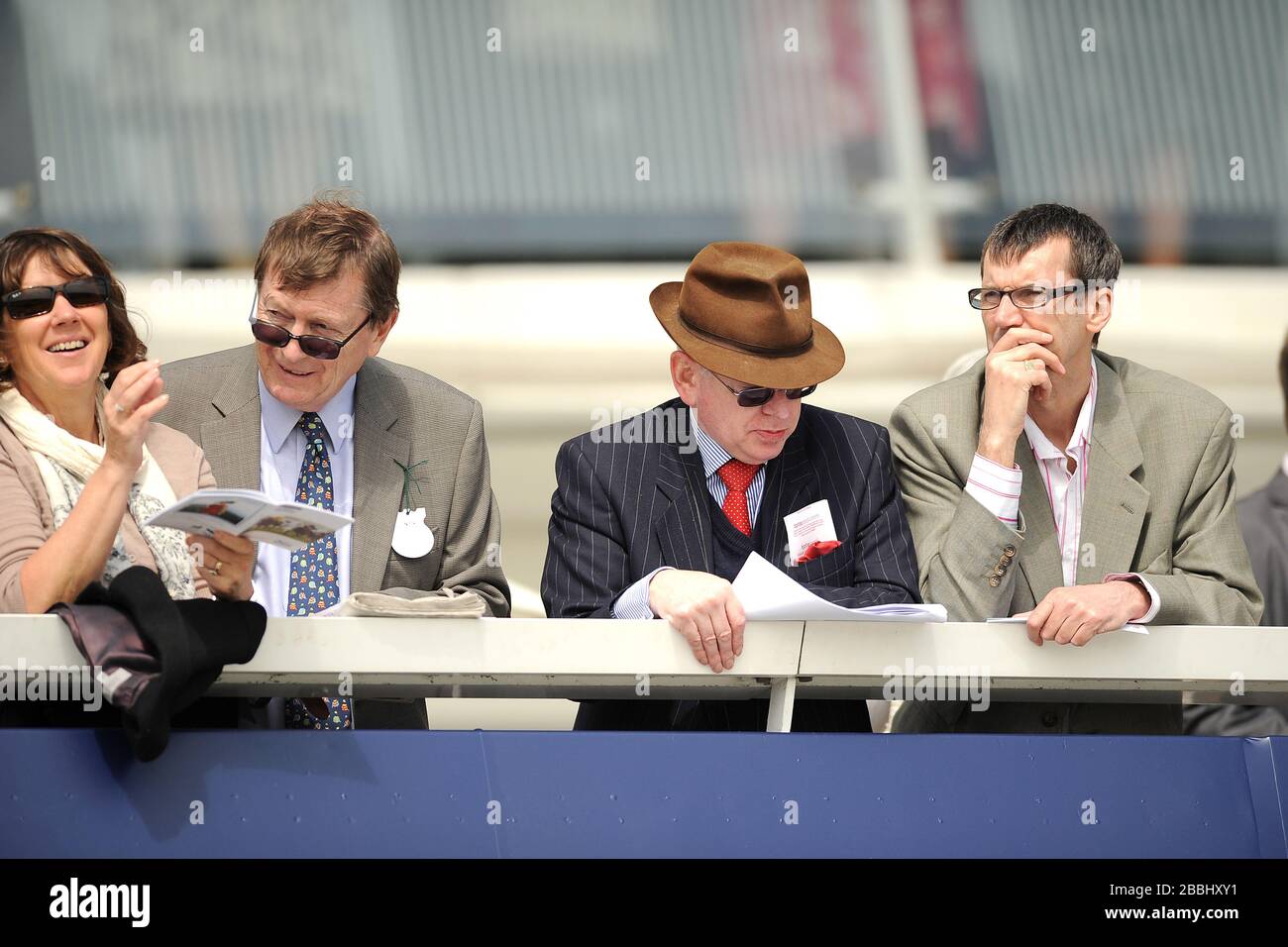 Racegoers goditi l'azione all'ippodromo di Epsom Downs Foto Stock