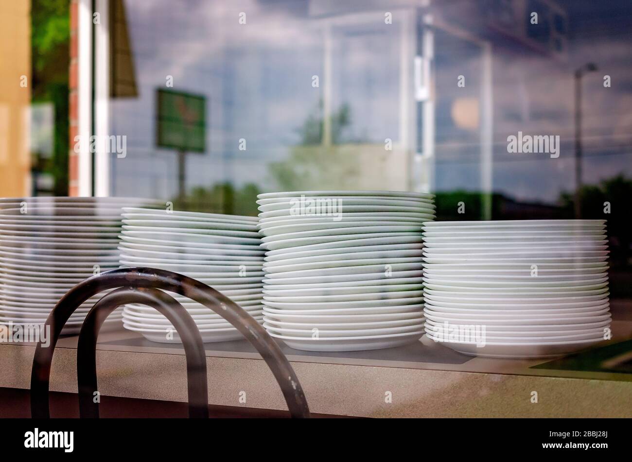 Le piastre vuote sono impilate su un banco presso una waffle House che ha chiuso a causa di COVID-19, 29 marzo 2020, in Mobile, Alabama. Foto Stock