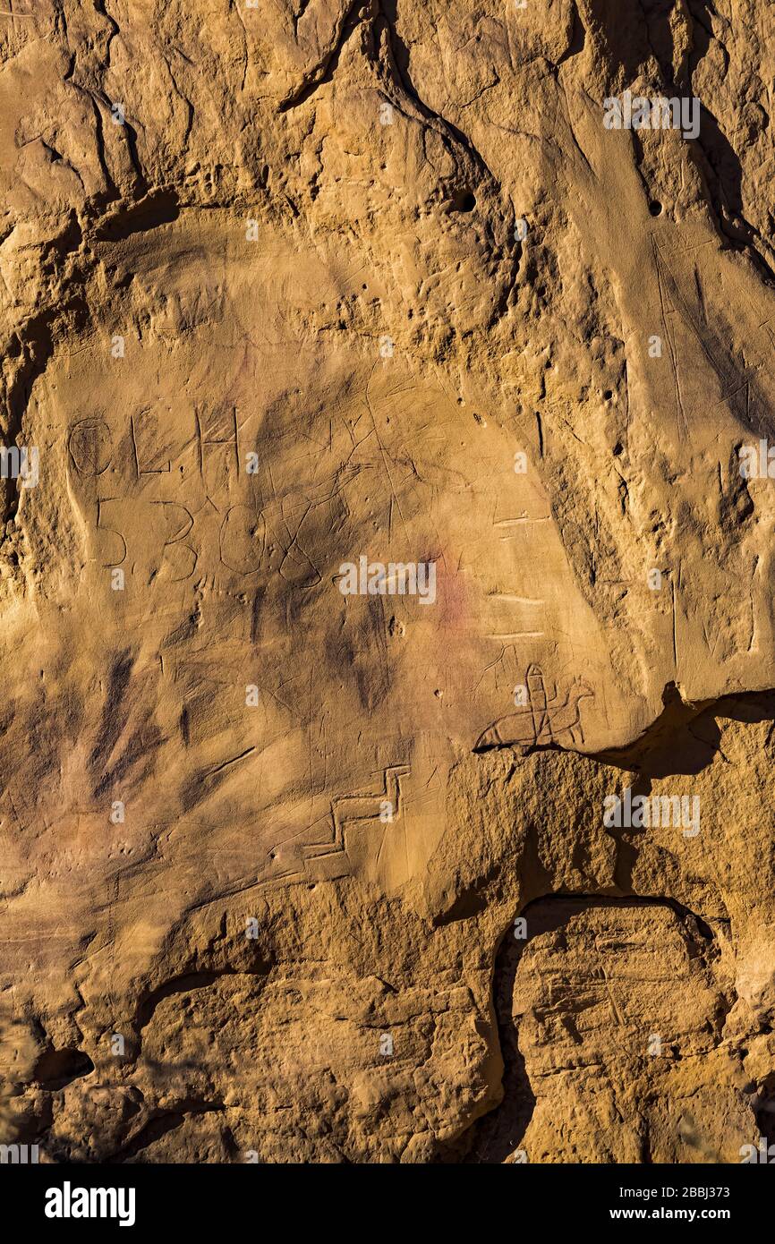 Graffiti con Petroglyphs scolpito dai popoli ancestrali Pueblo che un tempo occupavano Pueblo Bonito nel Chaco Culture National Historical Park, New Mexico Foto Stock