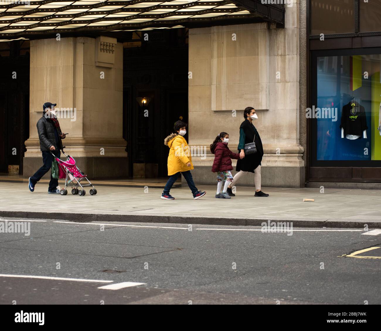 Una famiglia che indossa maschere facciali a Londra, Inghilterra Foto Stock