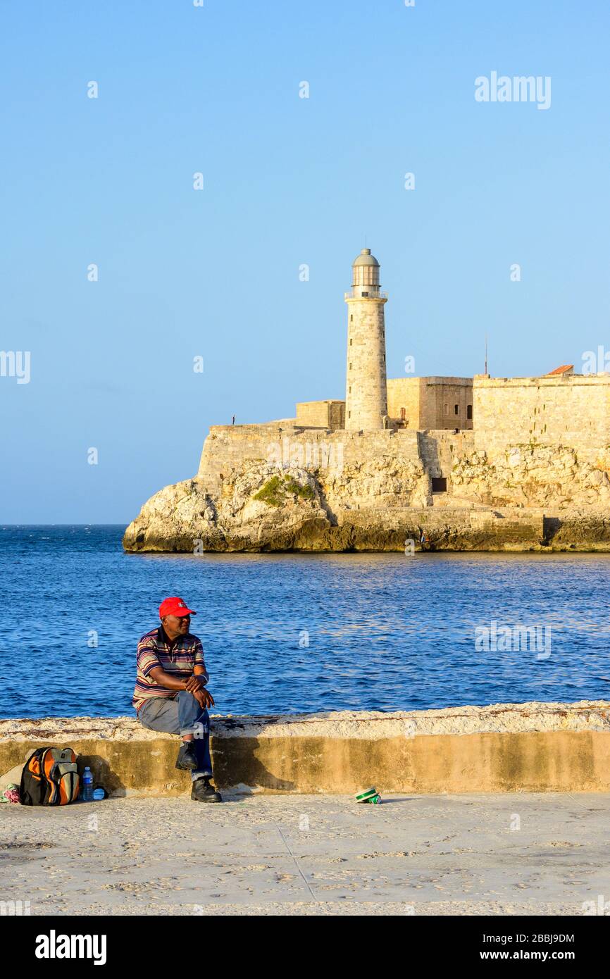 Resrting man, El Castillo de los Tres Reyes Magos del Morro o semplicemente "El Morro" in lontananza, l'Avana Vieja, Cuba Foto Stock