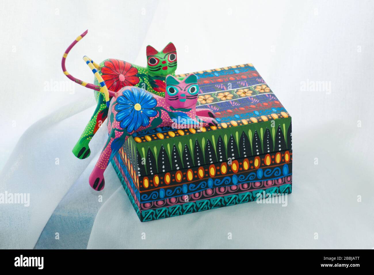 Scatola con due gatti scolpiti in legno e dipinti in colori tradizionali e puntini luminosi a Oaxaca, Messico Foto Stock