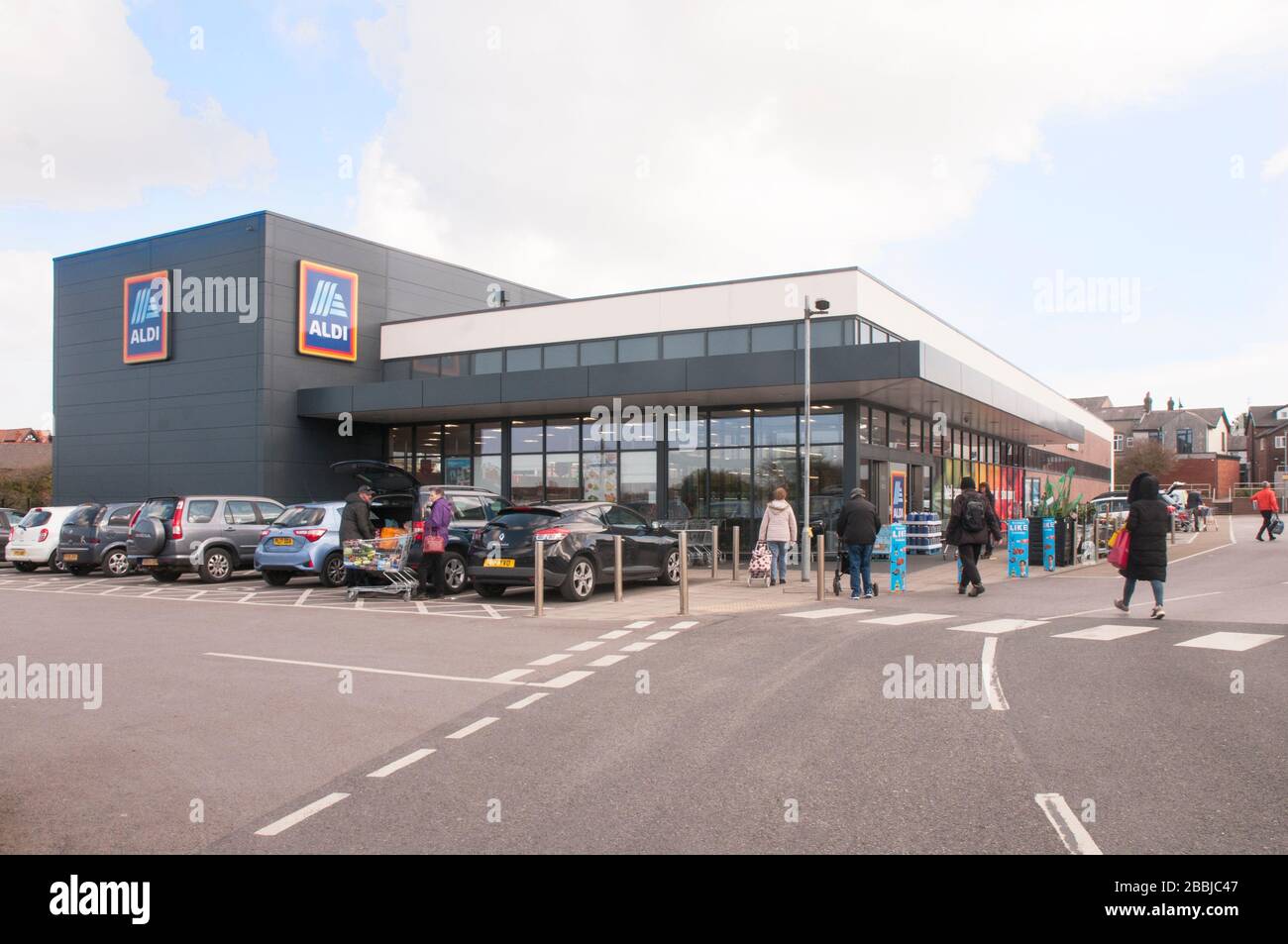 Gli acquirenti che vanno ad un negozio Aldi di nuova costruzione a Poulton le Fylde Lancashire Inghilterra UK che vende articoli di taglio dei costi come bevande, cibo, abbigliamento ecc. Foto Stock