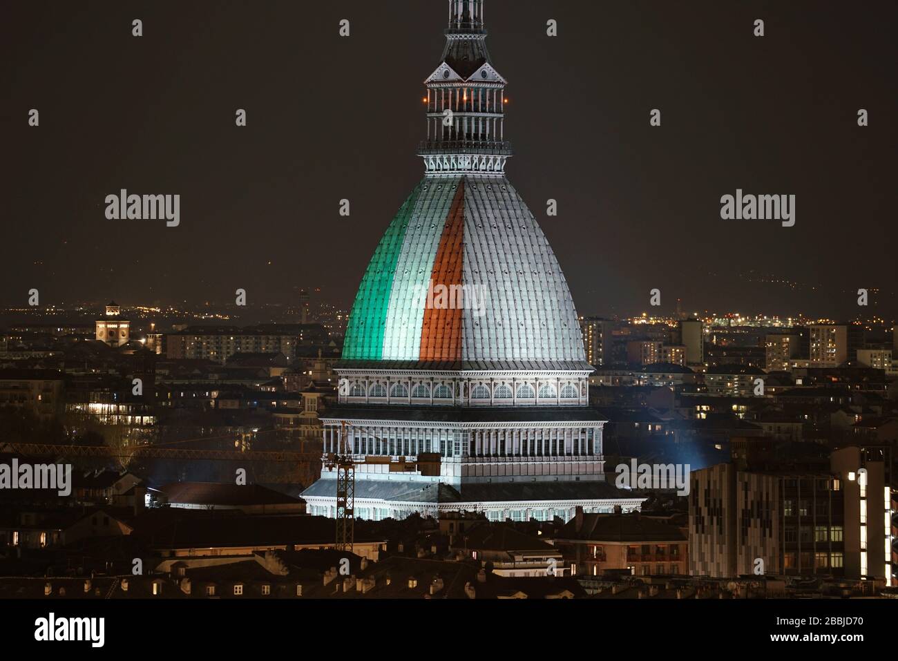 La Mole Antonelliana è illuminata dalla bandiera italiana per ricordare le numerose vittime della pandemia di coronavirus. TORINO, ITALIA - MARZO 2020 Foto Stock