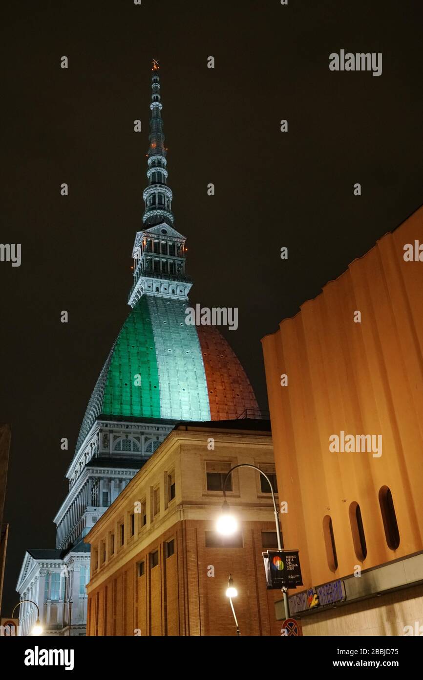 La Mole Antonelliana è illuminata dalla bandiera italiana per ricordare le numerose vittime della pandemia di coronavirus. TORINO, ITALIA - MARZO 2020 Foto Stock