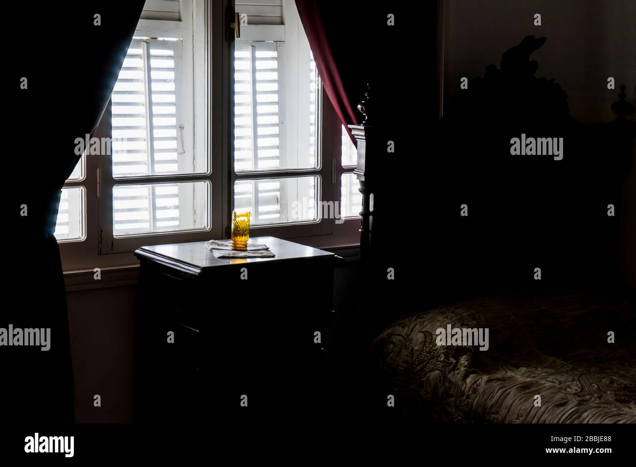 camera in stile retrò e luce di retromarcia dalla finestra. Sul ripiano è presente un vetro giallo. Molto vecchio cattivo e finestra in legno vecchio stile Foto Stock