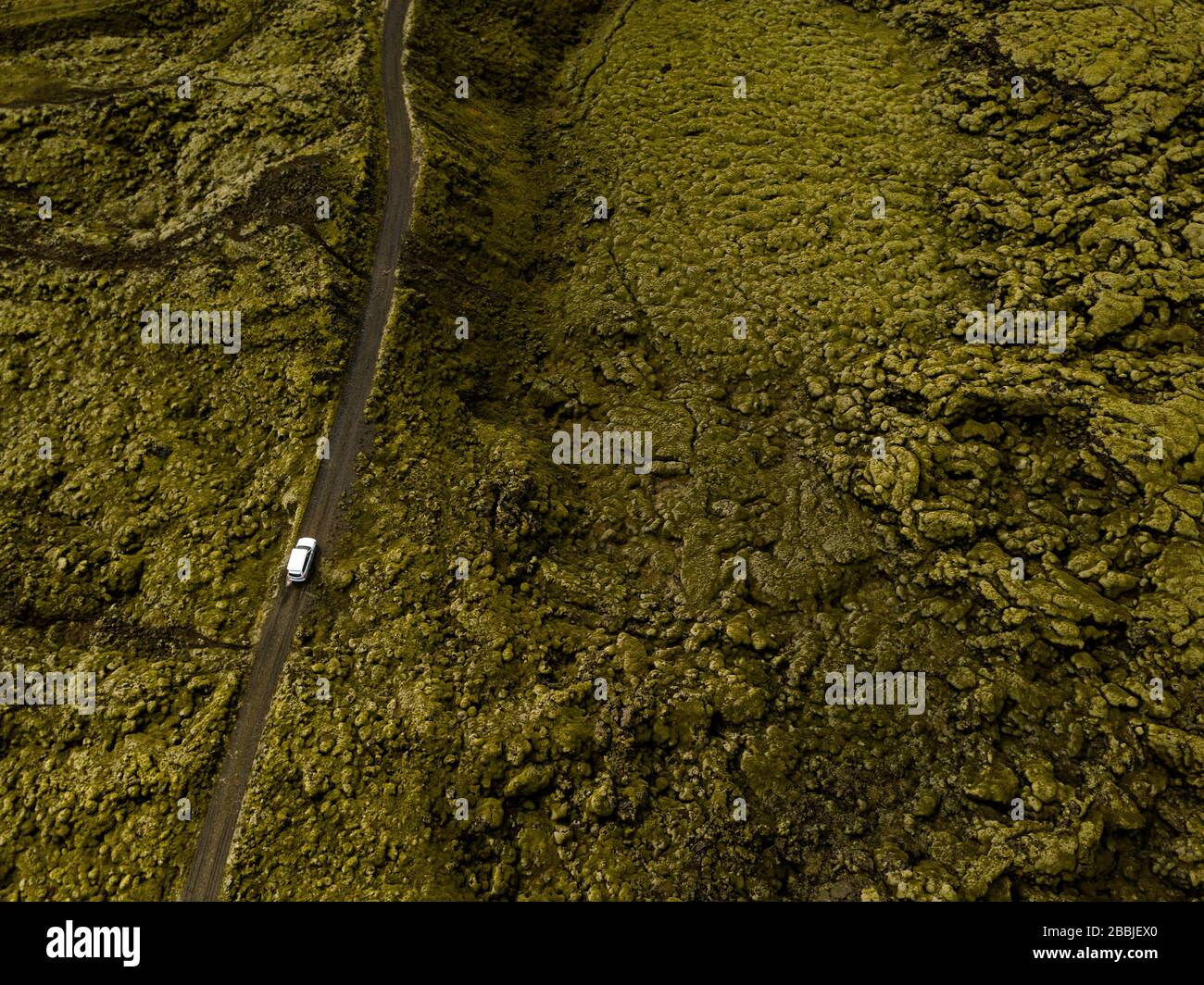 Vista aerea dell'auto che attraversa rocce laviche ricoperte di muschio in IC Foto Stock
