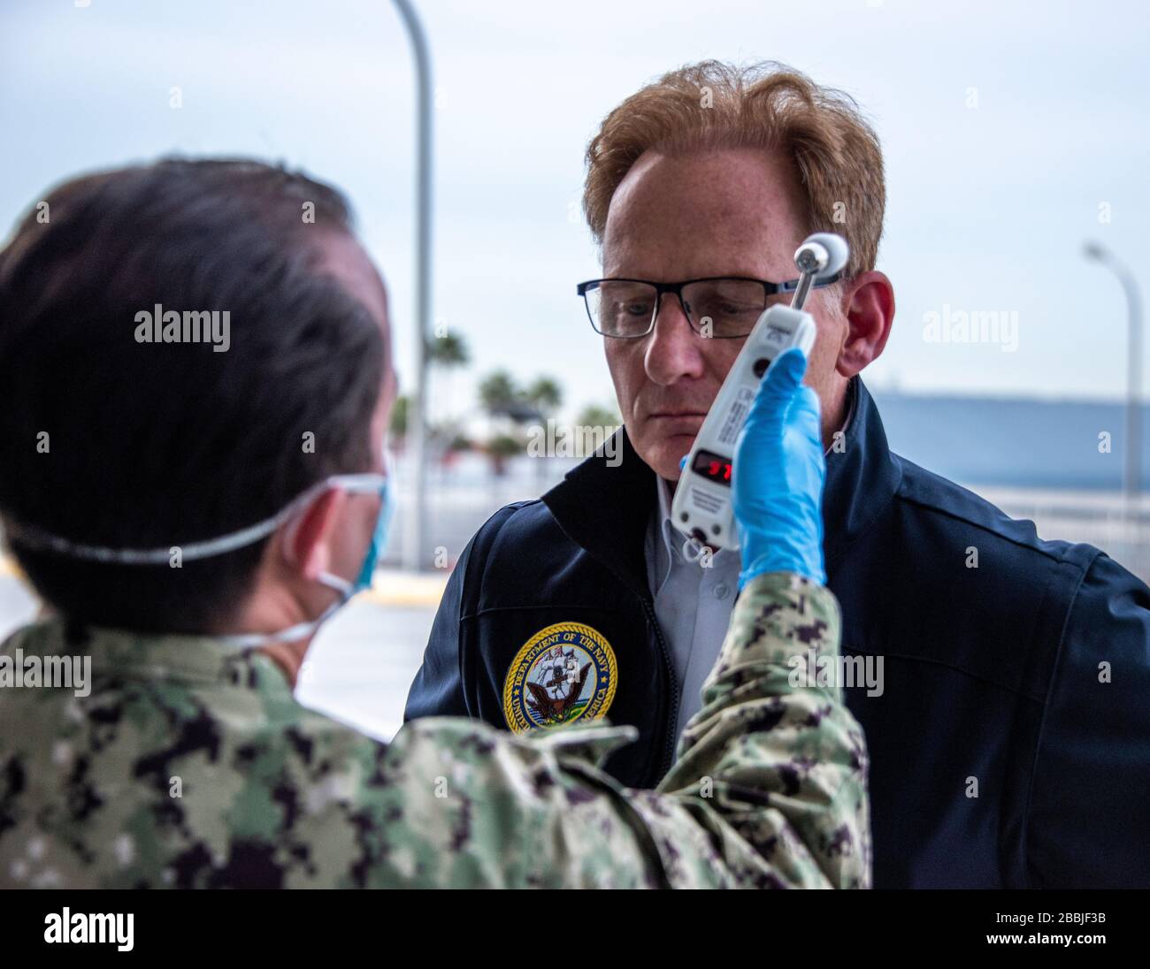 Los Angeles, Stati Uniti d'America. 31 marzo 2020. Il Segretario di Stato della Marina Thomas B. Modly ha la sua temperatura letta come parte di uno screening COVID-19 prima di un tour della nave militare dell'ospedale militare Sealift Command USNS Mercy ormeggiata al Los Angeles World Cruise Center il 31 marzo 2020 a Los Angeles, California. Credito: Natalie Byers/U.S. Navy Photo/Alamy Live News Foto Stock