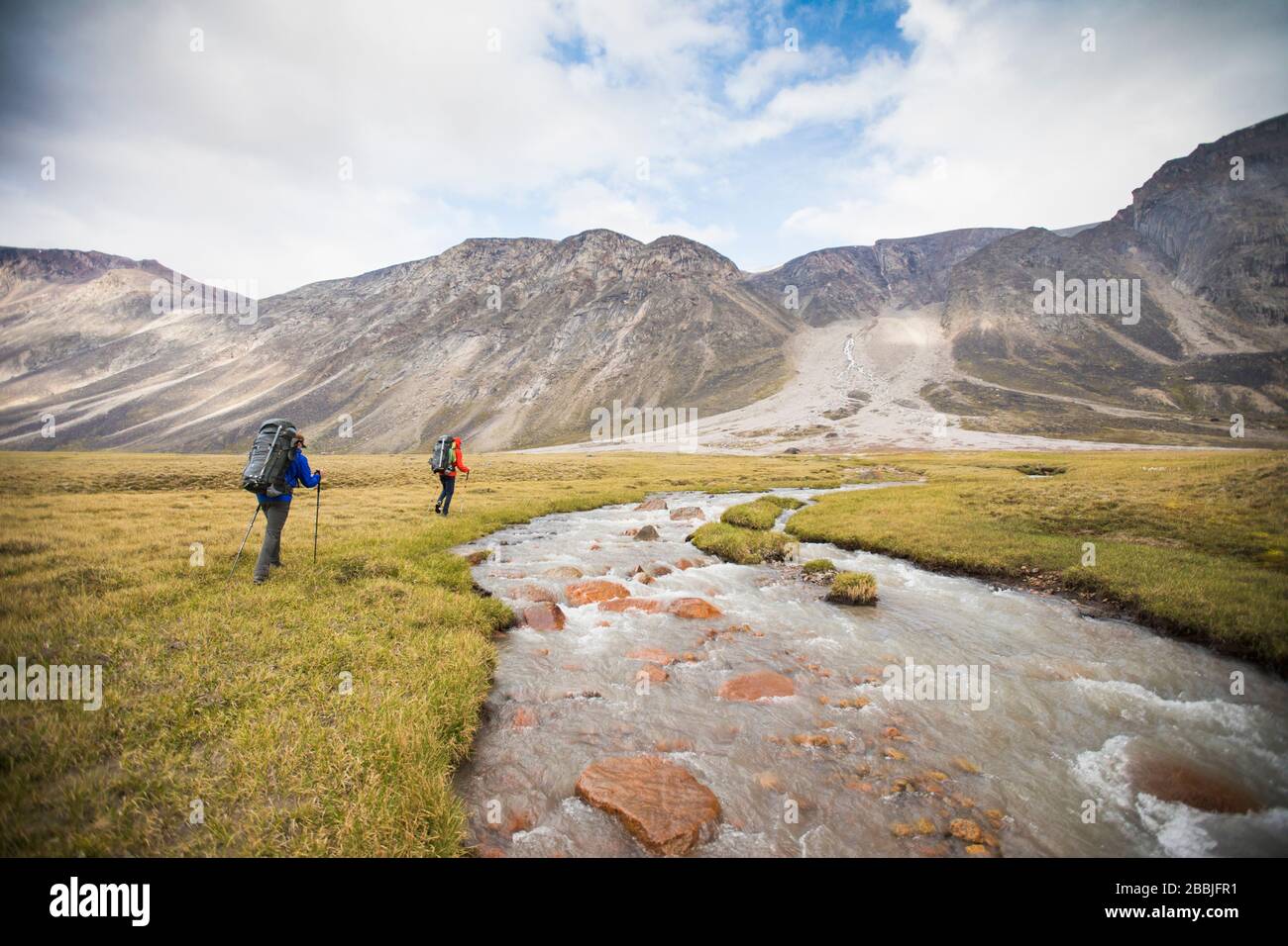 Due backpackers escursione a monte del fiume per trovare attraversamento sicuro. Foto Stock