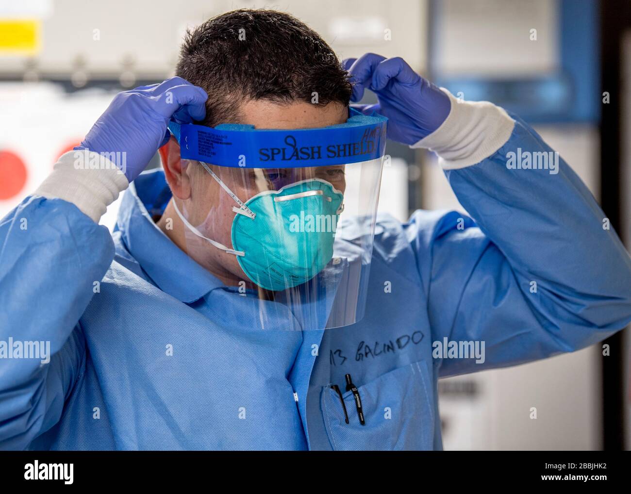 U.S. Navy Hospital Corpsman 3rd Class Erick Galindo, indossa un paraspruzzi nel micro laboratorio a bordo della nave ospedaliera USNS Mercy per assistere con COVID-19, soccorso pandemico del coronavirus 30 marzo 2020 a Los Angeles, California. Foto Stock