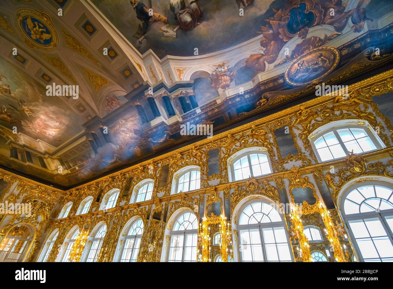 Una sala da ballo decorata con interni dorati con un soffitto dipinto colorato all'interno della sala da ballo del Palazzo di Caterina Rococo a Pushkin, vicino a San Pietroburgo, Russia. Foto Stock