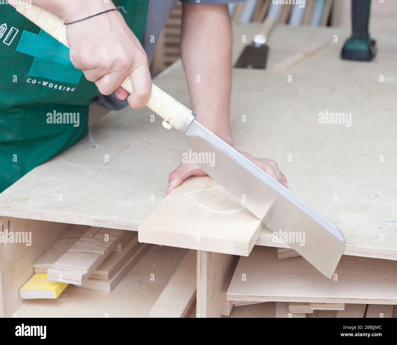 Le mani del falegname. Giovane hippster bearded in un'officina di carpenteria sega giapponese fresco. Foto Stock