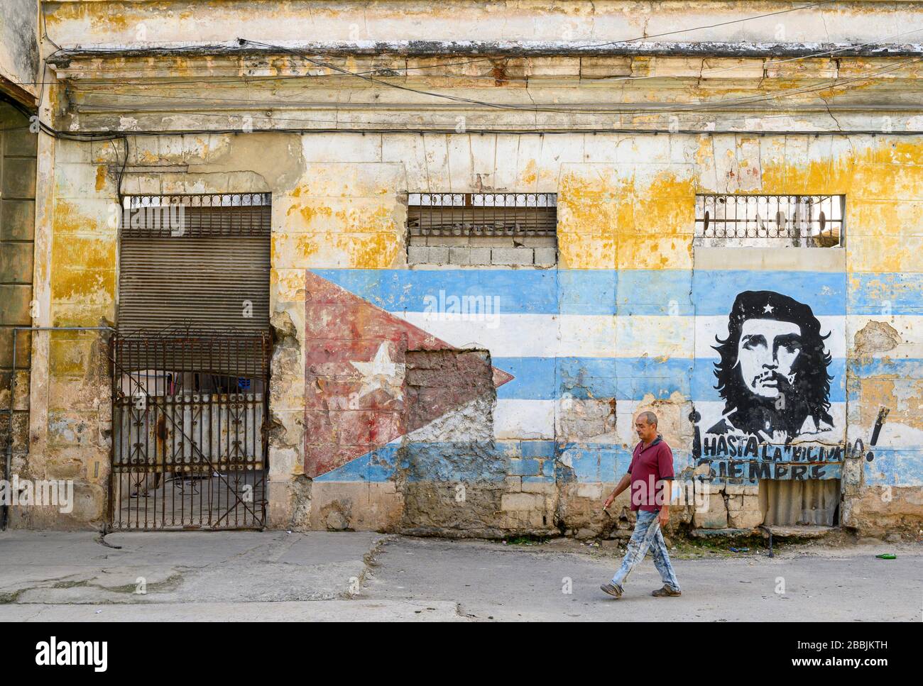 Murale con bandiera cubana e che Guevara con passanti, l'Avana, Cuba Foto Stock