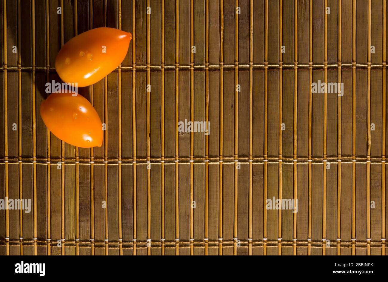 Autunno ancora vita - pomodori al cioccolato e giallo su mat di bambù Foto Stock