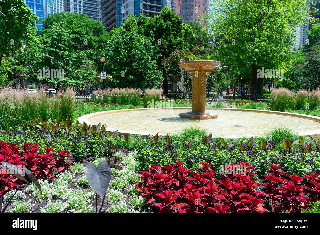 Fontana al Washington Square Park di Chicago circondato da piante e fiori Foto Stock