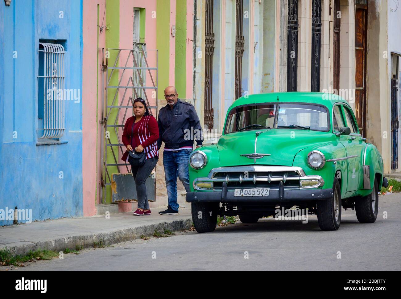 Vecchia Chevrolet e passando la coppia, l'Avana, Cuba Foto Stock