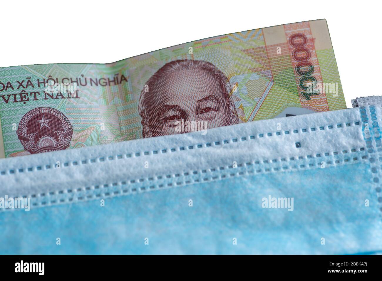 Note bancarie sotto maschera facciale - simbolo della pandemia globale del virus corona sull'economia Foto Stock