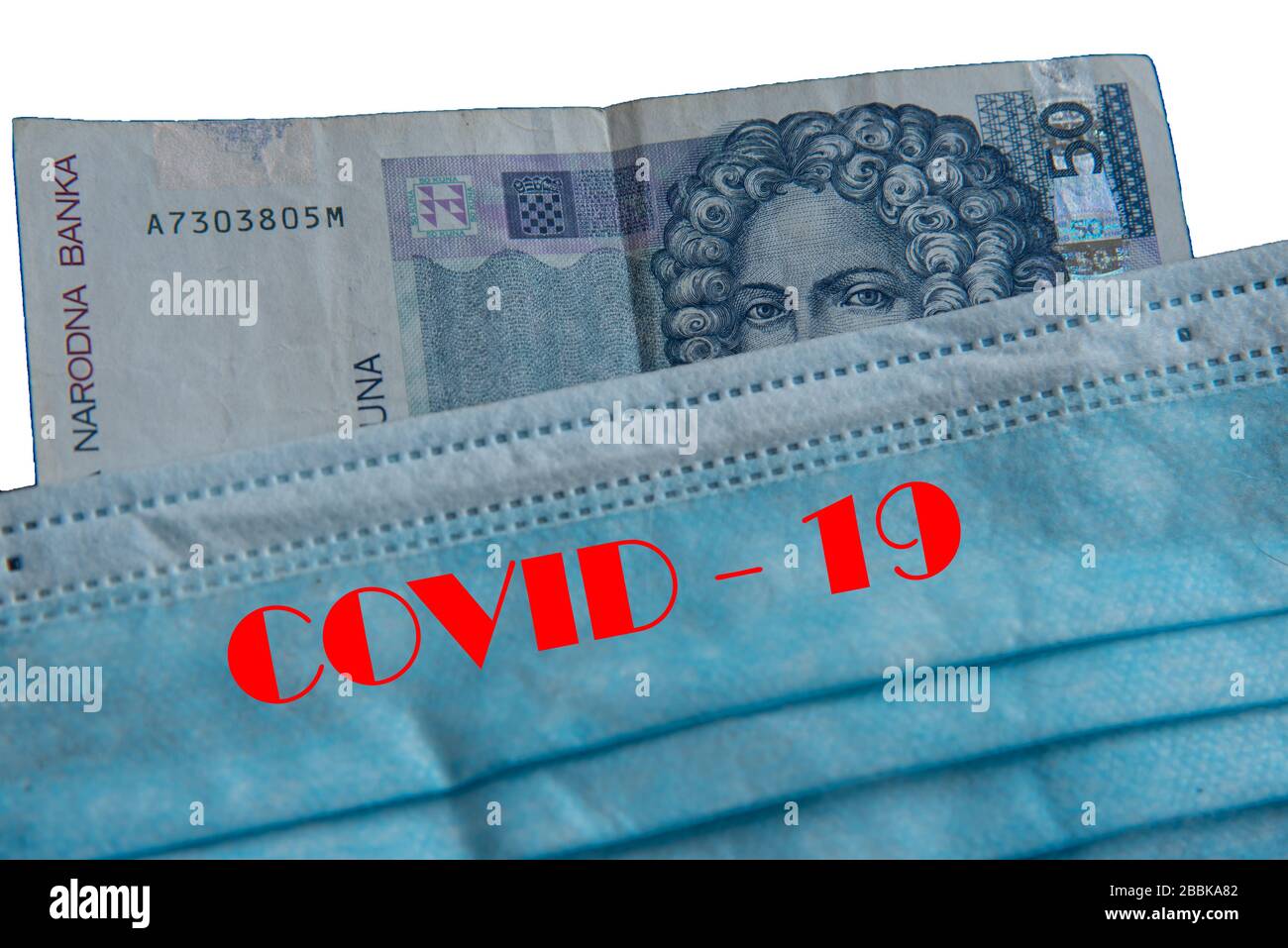 Note bancarie sotto maschera facciale - simbolo della pandemia globale del virus corona sull'economia Foto Stock