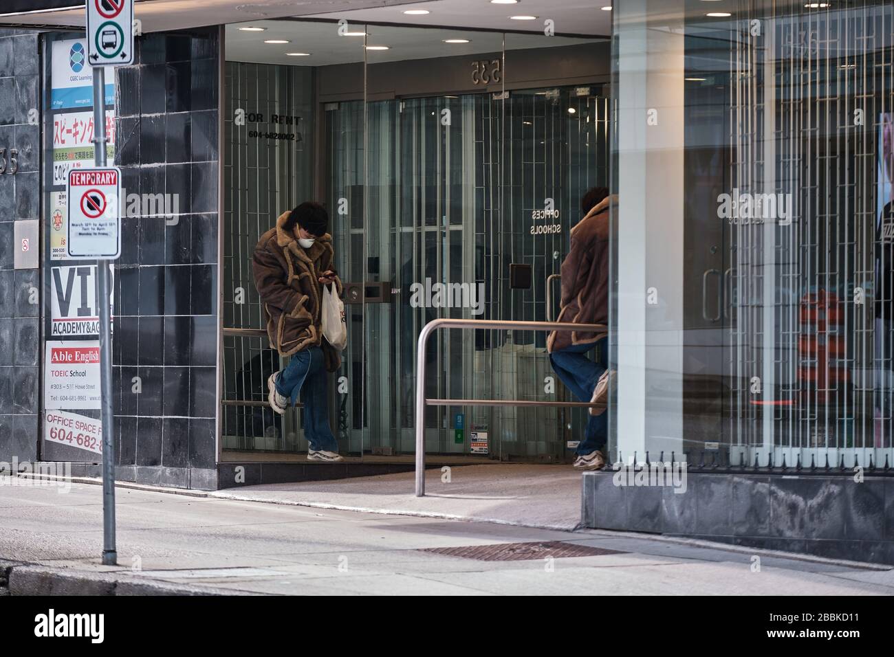 VANCOUVER, BC, CANADA - MAR 24, 2020: Civili che indossano gli attrezzi protettivi come la maschera ed i guanti in mezzo al panico comprando come il coronavirus si diffonde. Foto Stock