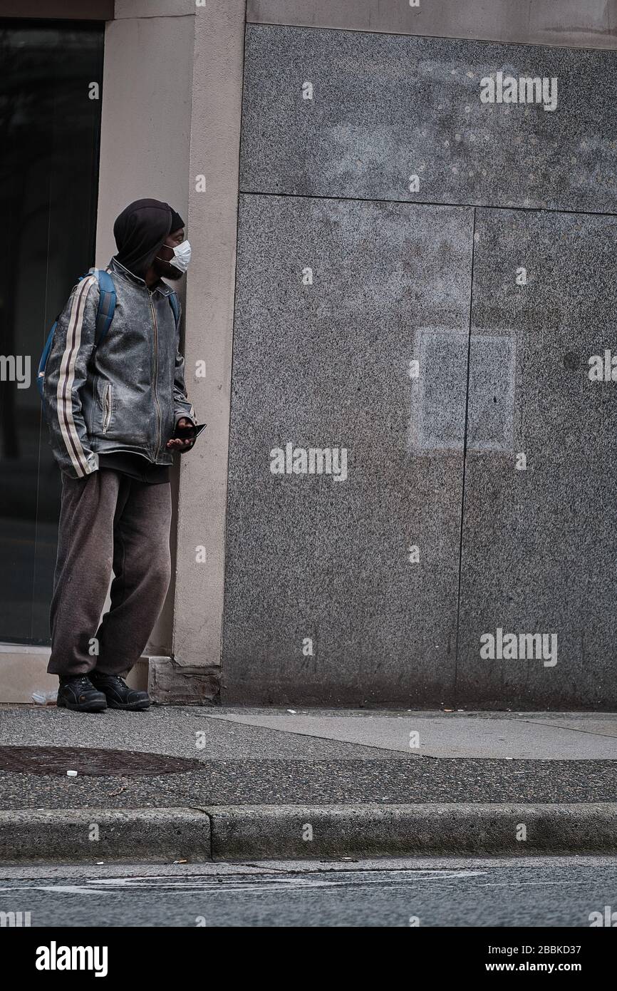 VANCOUVER, BC, CANADA - MAR 24, 2020: Civili che indossano gli attrezzi protettivi come la maschera ed i guanti in mezzo al panico comprando come il coronavirus si diffonde. Foto Stock