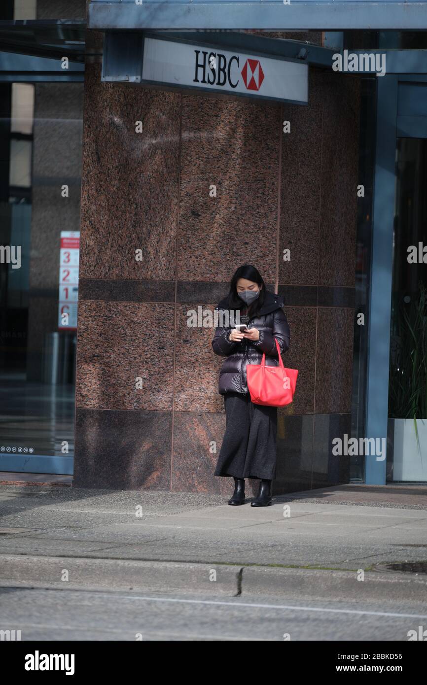 VANCOUVER, BC, CANADA - MAR 24, 2020: Civili che indossano gli attrezzi protettivi come la maschera ed i guanti in mezzo al panico comprando come il coronavirus si diffonde. Foto Stock