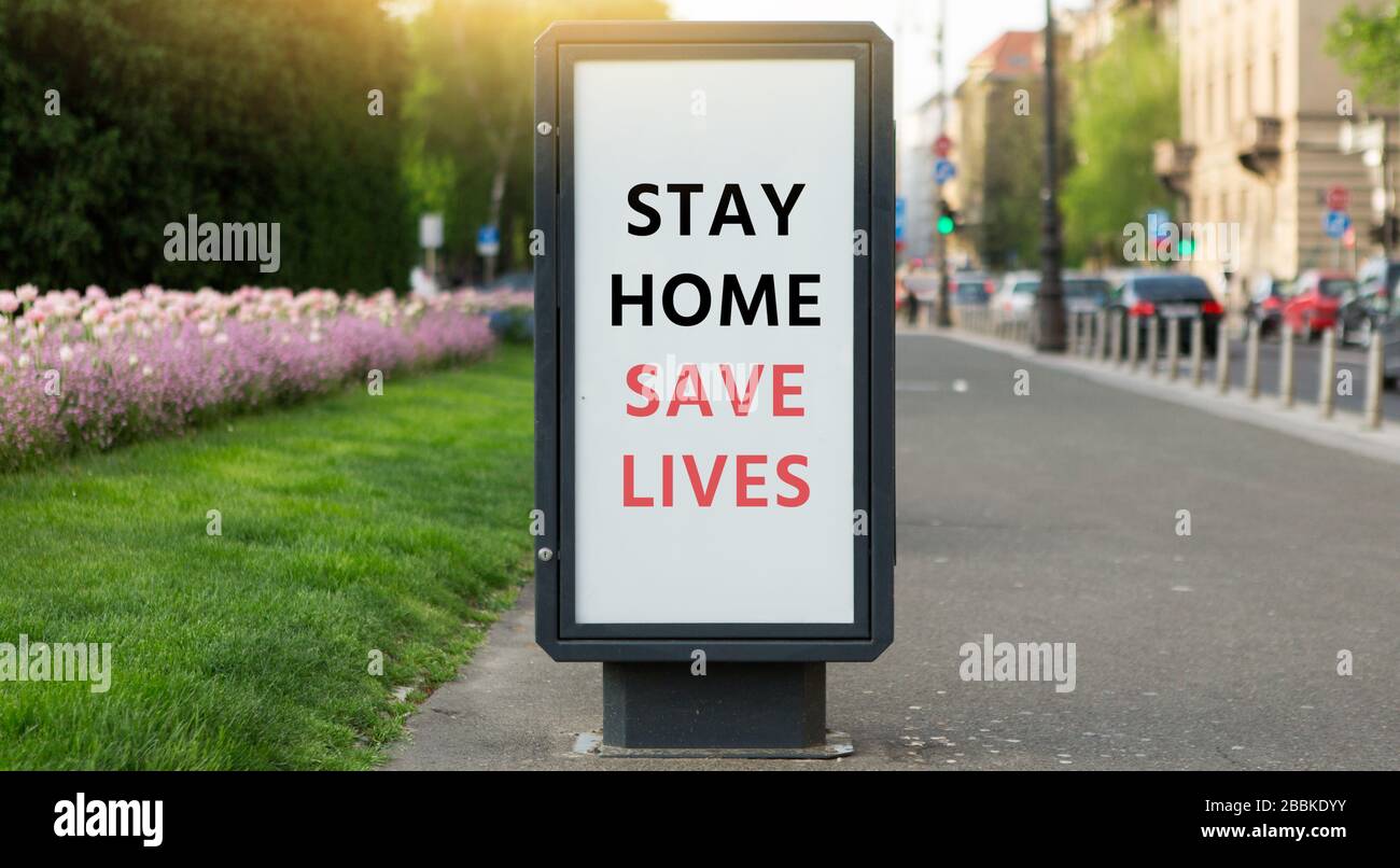 Banner di strada con l'iscrizione 'Tay home Save lives'. Isolamento automatico in quarantena Foto Stock