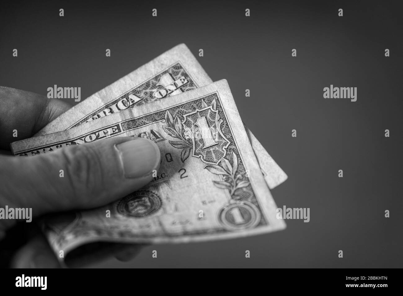 La persona tiene un dollaro nella sua mano. Bianco e nero. Primo piano. Foto Stock