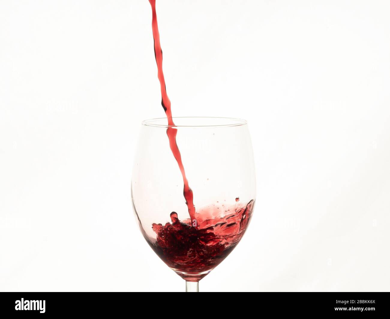 Primo piano di vino rosso che si tuffa nel bicchiere Foto Stock