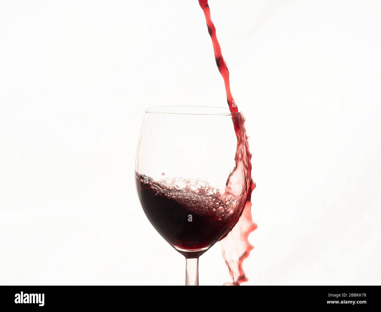 Colpo di cornice pieno di vino rosso che si tuffa in vetro Foto Stock