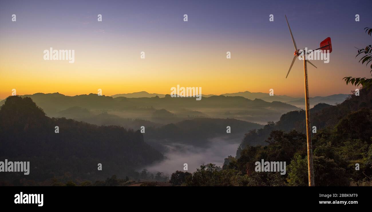 Turbina con nebbiosa montagna durante sunrise background.Natural paesaggio estivo. Foto Stock