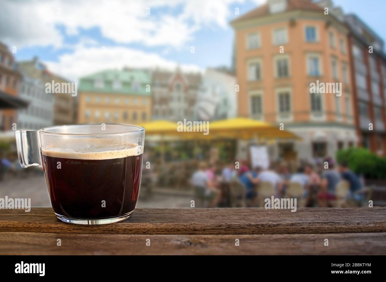 Una tazza di caffè nero su un tavolo con sfondo quadrato e caffè Foto Stock