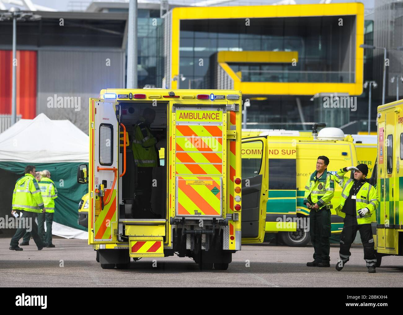 Gli equipaggi delle ambulanze attendono i primi pazienti nel centro Excel di Londra, che viene inserito nel temporaneo ospedale NHS Nightingale per aiutare ad affrontare il coronavirus. Foto Stock