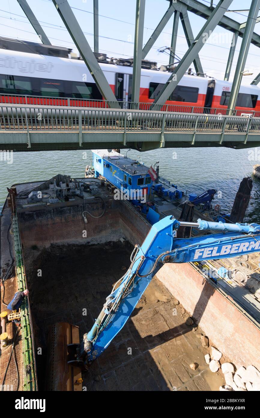 Vienna, Vienna: Escavatore della società Felbermayr riempie le pietre alle fondazioni delle strutture di ponte subacqueo al ponte Nordbahnbrücke per la protec Foto Stock
