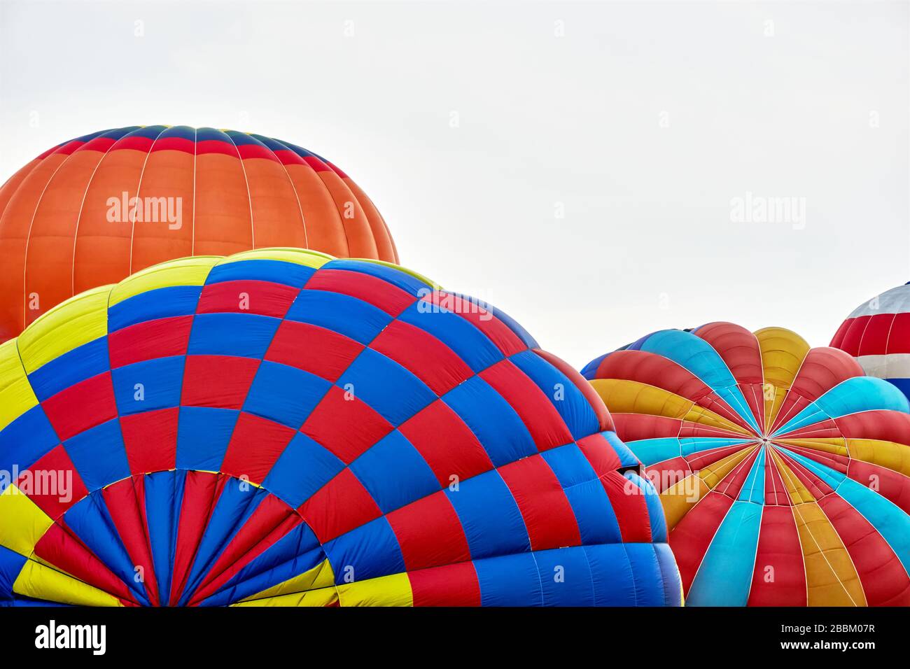 Palloncini ad aria calda. Molti palloncini ad aria calda multicolore contro un cielo grigio nuvoloso con spazio per le copie. Da utilizzare come sfondo estivo. Foto Stock