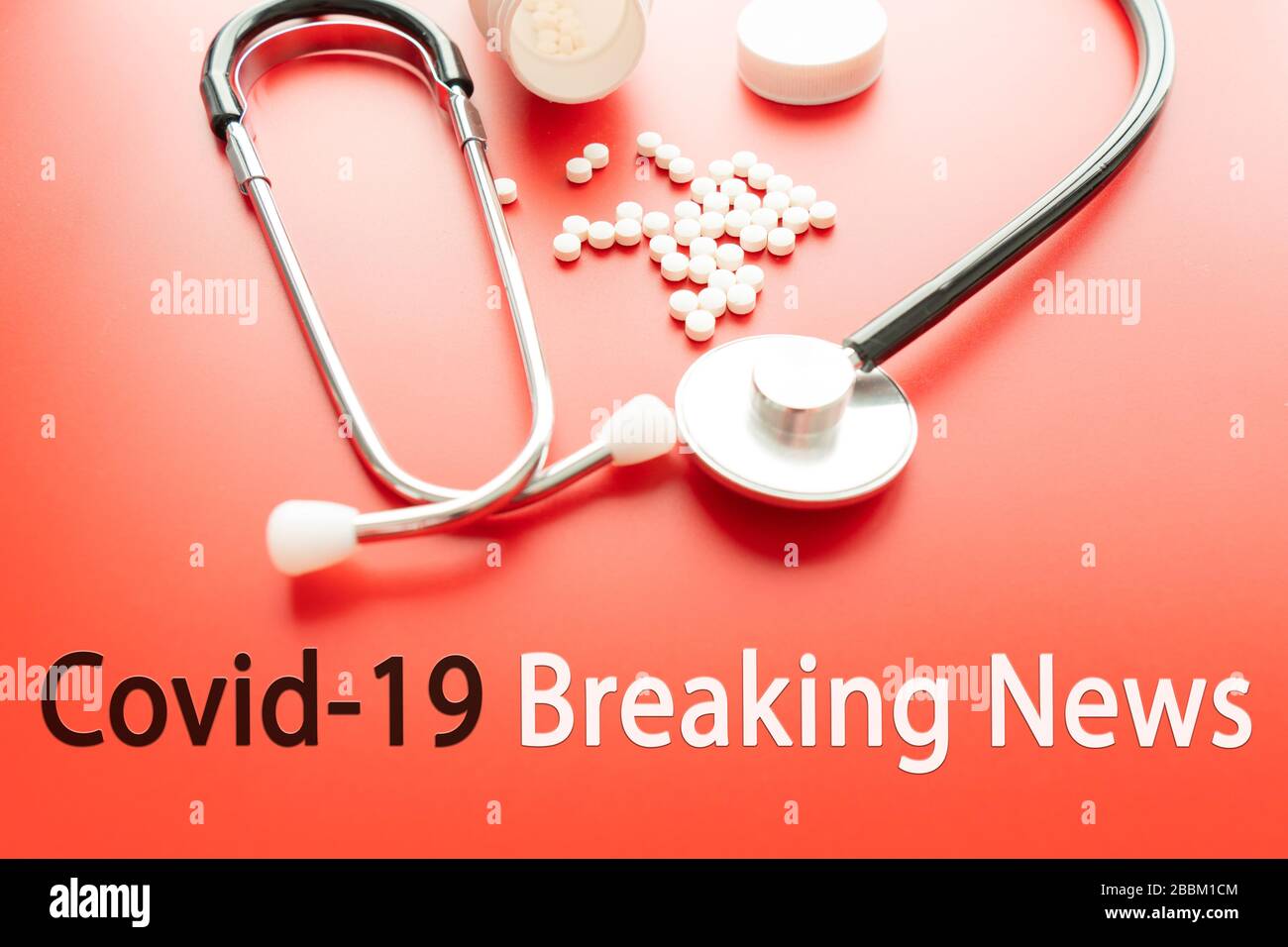 COVID 19 BREAKING NEWS text with stetoscope and glosing glass on red background. Covid-19 o Coronavirus Concept Foto Stock