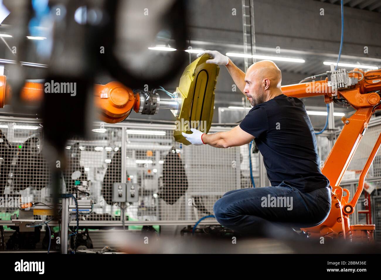 L'ingegnere che ripara un robot automatico si muove nel settore automobilistico, in una fabbrica intelligente, in un concetto industriale Foto Stock