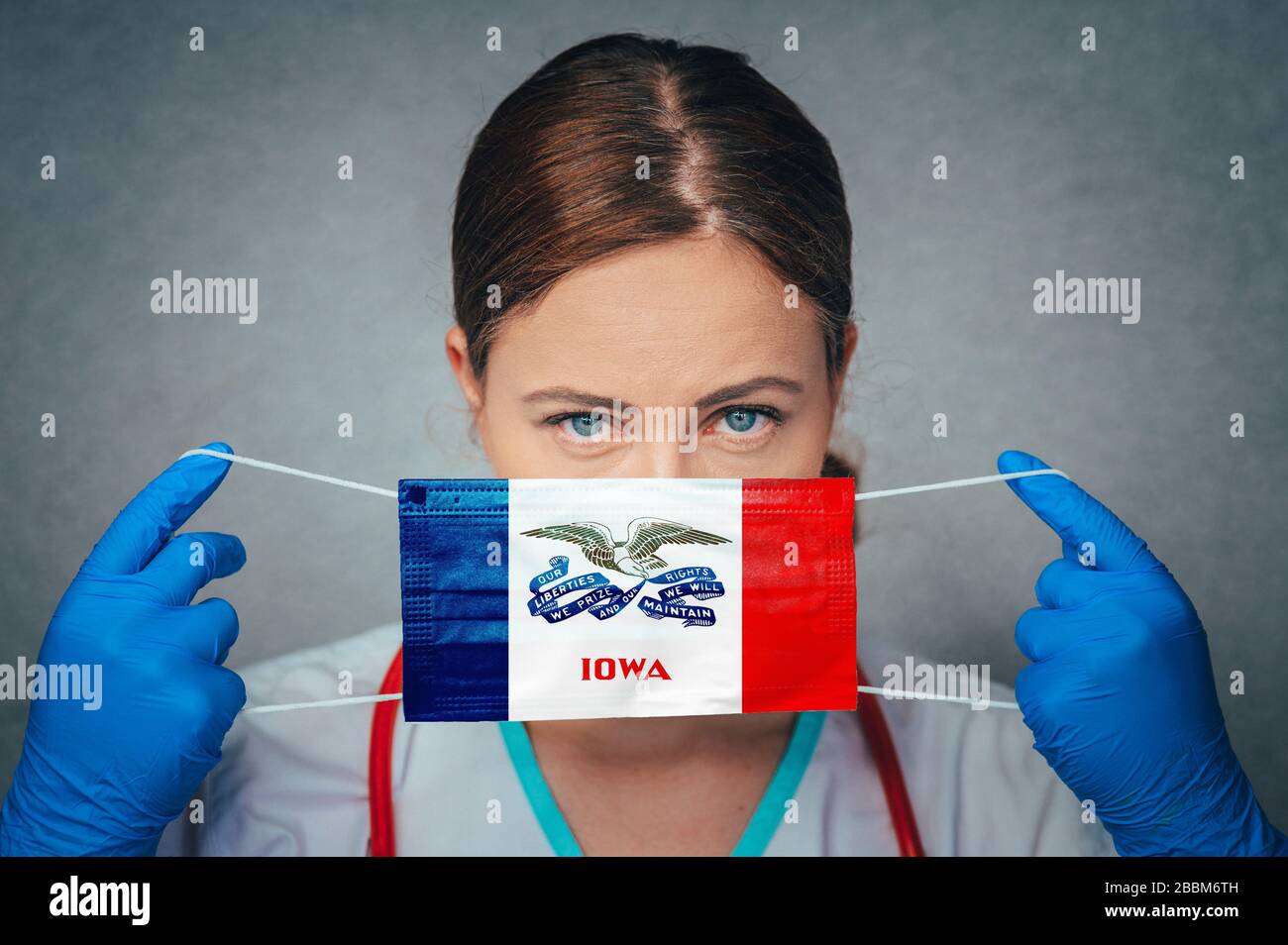 Coronavirus negli Stati Uniti Iowa, femmina Doctor Portrait, proteggere maschera medica chirurgica viso con Iowa Flag. Malattia, virus Covid-19 in Iowa Foto Stock