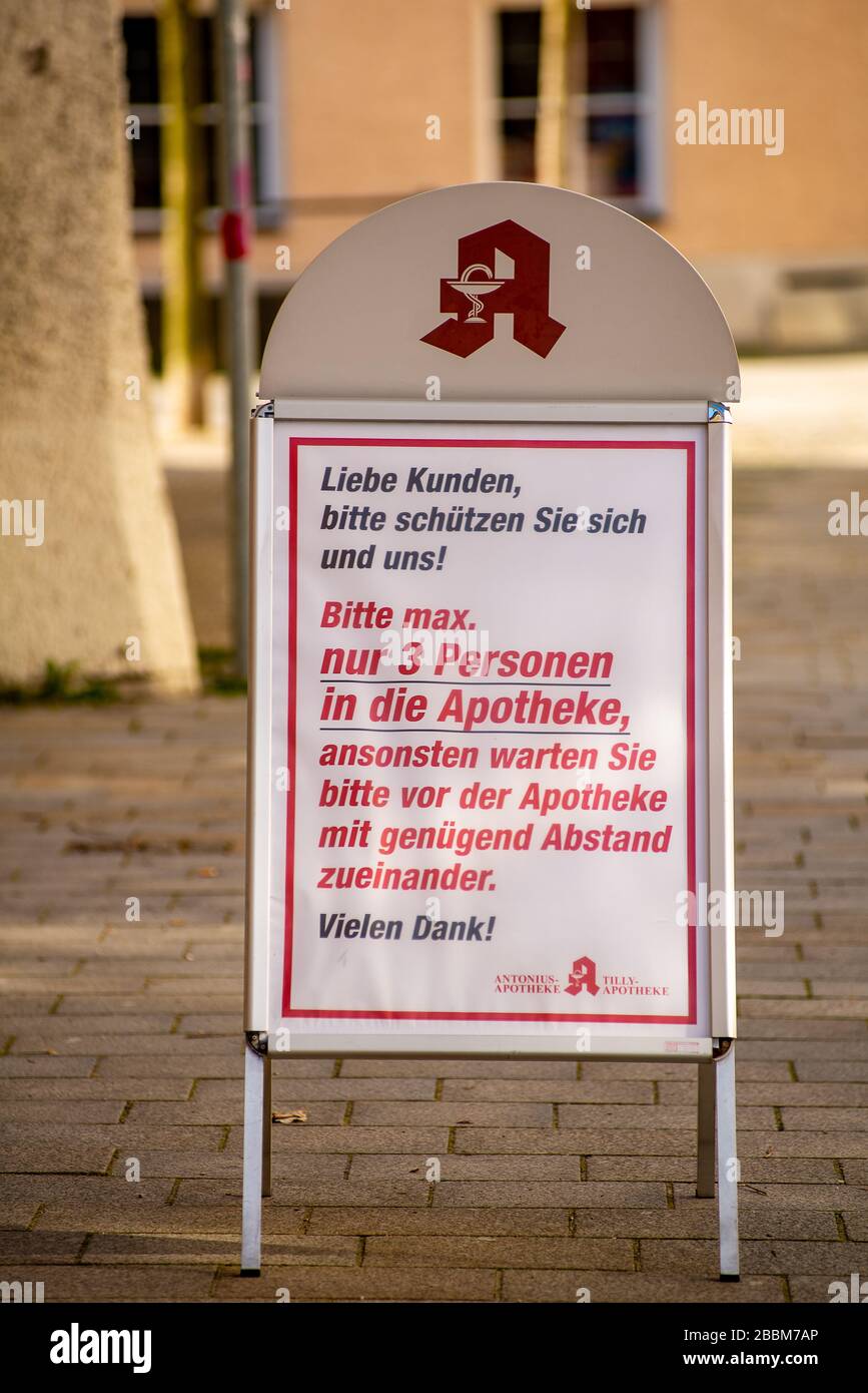 Altoetting, Germania-1 aprile 2020: Un segno in tedesco fuori di una farmacia chiede alle persone di proteggere il personale della farmacia e se stesse non andando più di t. Foto Stock