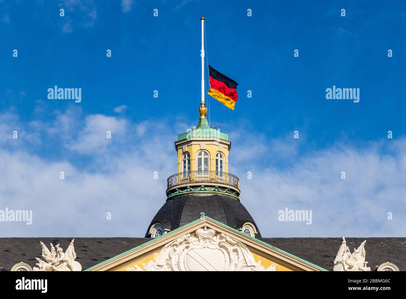 Vista ravvicinata sulla bandiera tedesca a Halfmast, auf Halbmast, sul tetto della torre del castello di Karlsruhe. Baden-Württemberg, Germania Foto Stock
