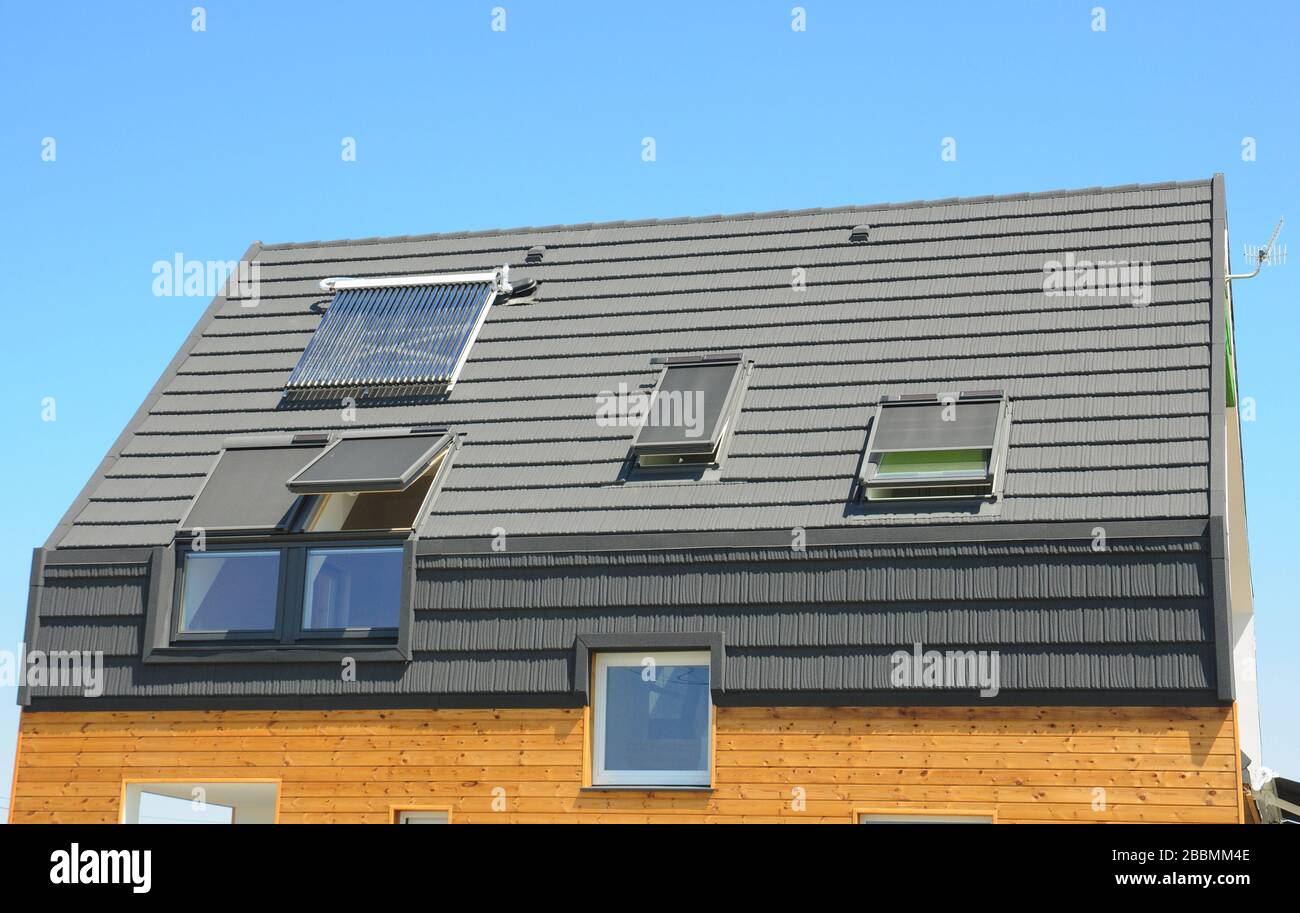 Casa moderna attico tetto con lucernario finestre e riscaldamento solare acqua. Foto Stock