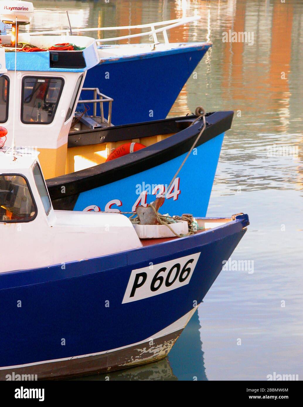 Gli archi di tre barche blu da pesca ormeggiate a Camber Dock, Portsmouth, Hampshire, Inghilterra, Regno Unito Foto Stock