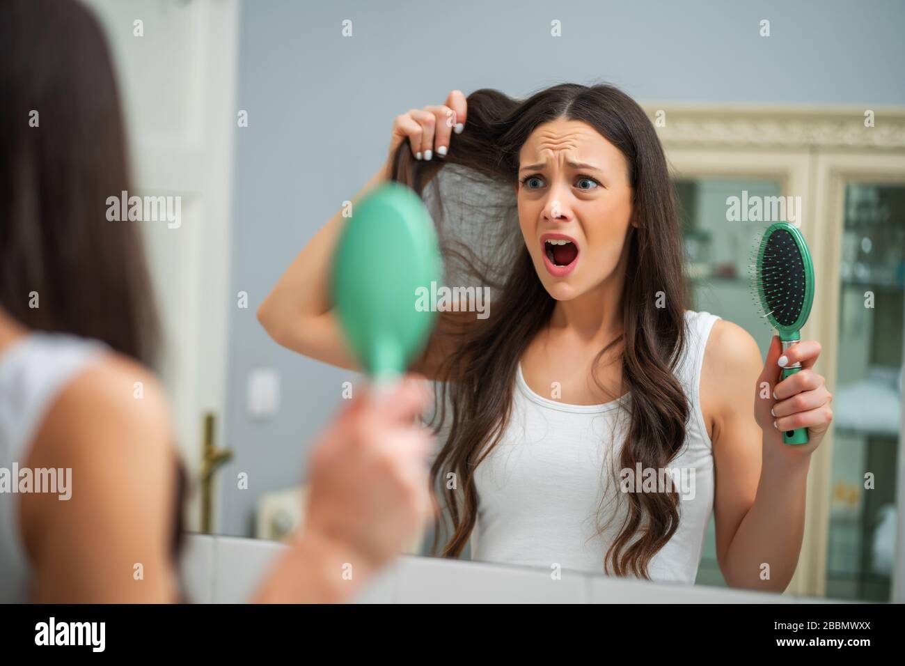Giovane donna è in preda al panico a causa di perdita di capelli. Foto Stock