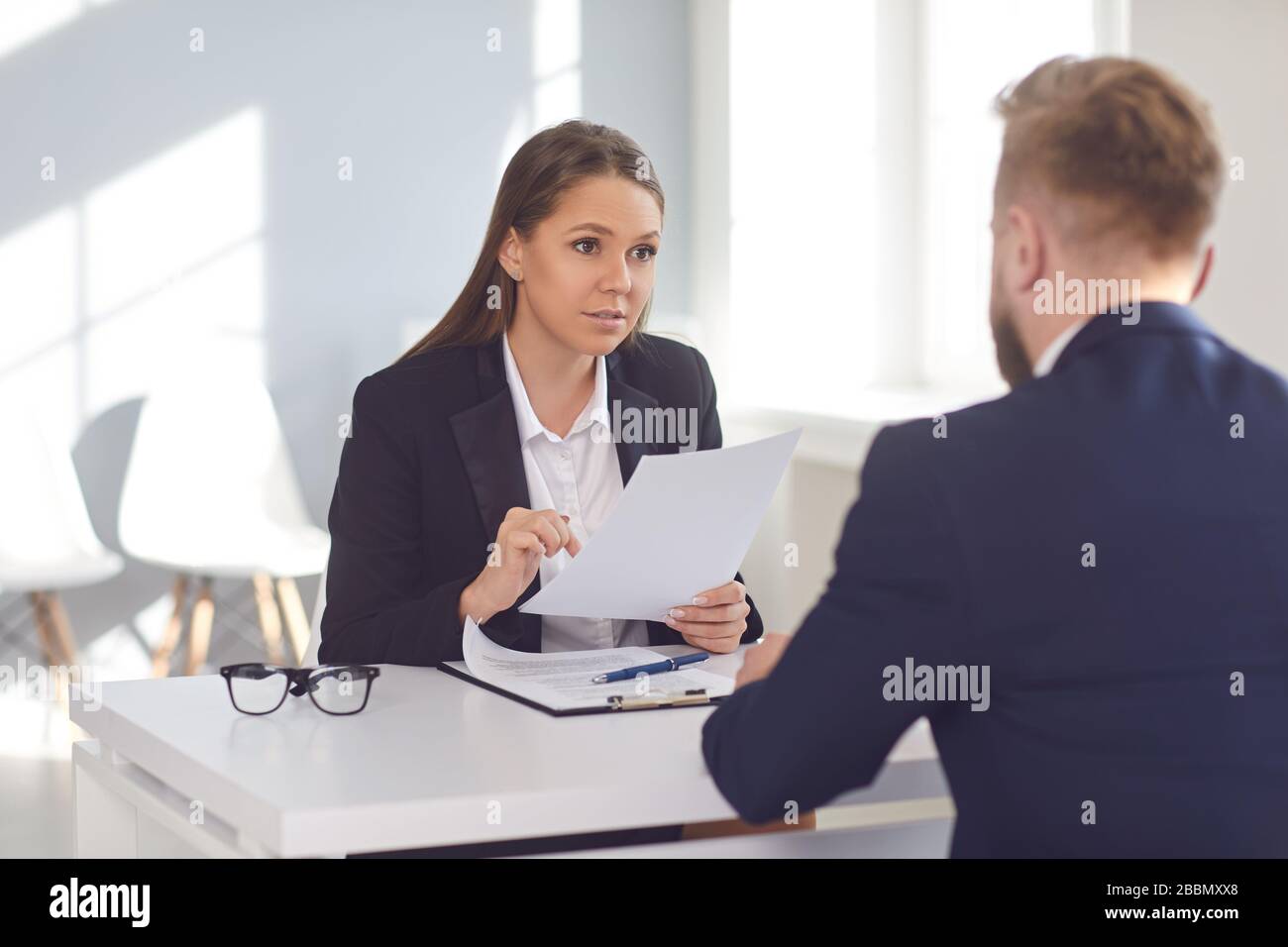Donna datore di lavoro che parla intervista un uomo per un posto di lavoro vacante in un'azienda Foto Stock