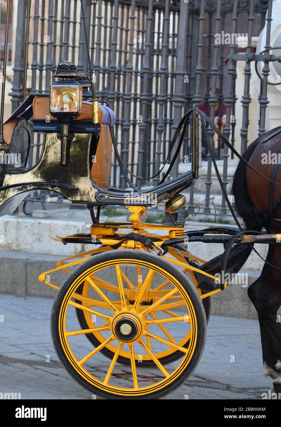 Scena di strada spagnola. Carrozza tradizionale trainata da cavalli in attesa a Siviglia, Andalusia, Spagna. Sezione luccicante di un carrello. Tempo Siesta. Schermo intero Foto Stock
