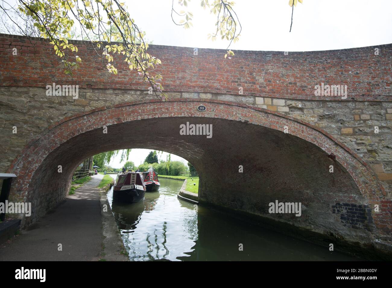 Due barche per canali che vanno sotto il ponte al canale Stoke Bruene, Inghilterra Foto Stock
