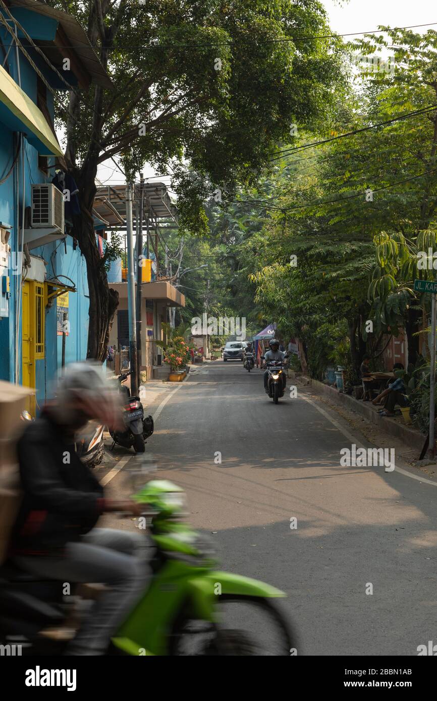 Jakarta, Indonesia - 13 luglio 2019: Un corriere del pacco naviga a piena velocità, senza prestare molta attenzione intorno a lui, lungo la via Kartini Raya. Foto Stock