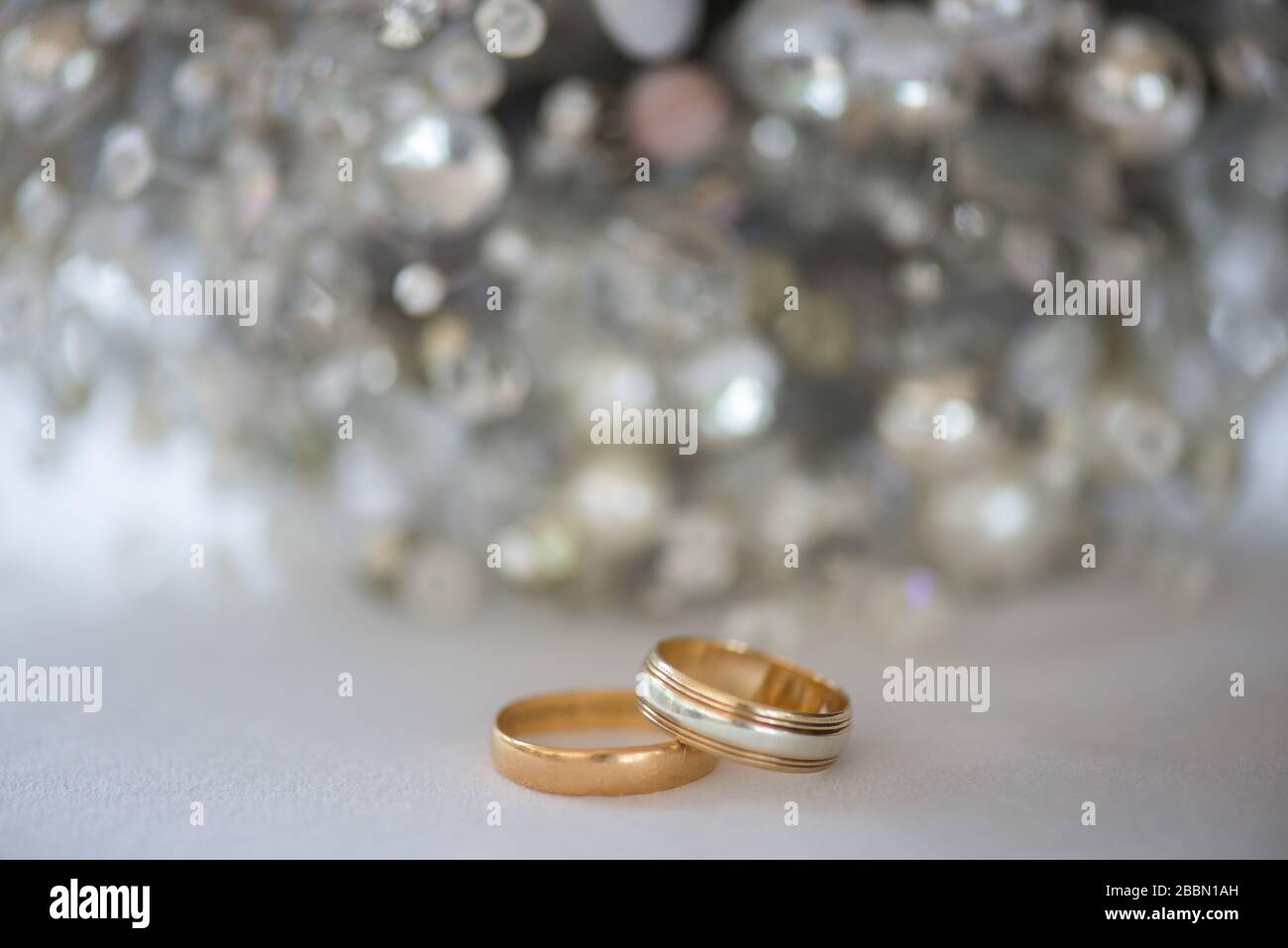 Due anelli per matrimoni in oro e platino con sfondo argento brillante. Towcester, Inghilterra Foto Stock