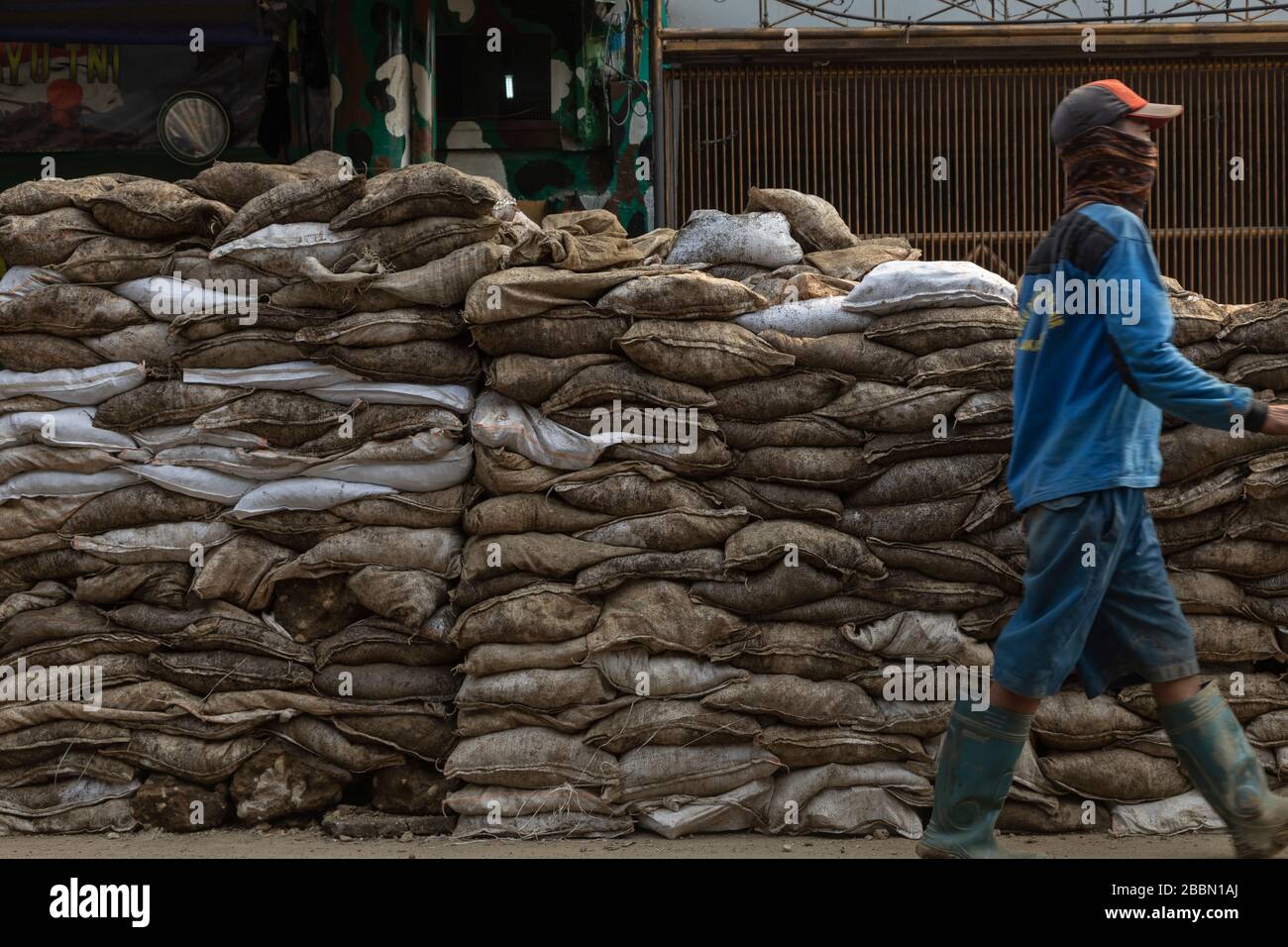 Jakarta, Indonesia - 13 luglio 2019: Un gruppo di addetti alla manutenzione lavorano rudimentaryly scavando fossati, riempendo sacchi di suolo e fissando tubi di liquame. Foto Stock